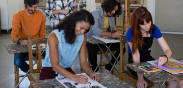 female instructor examining students painting